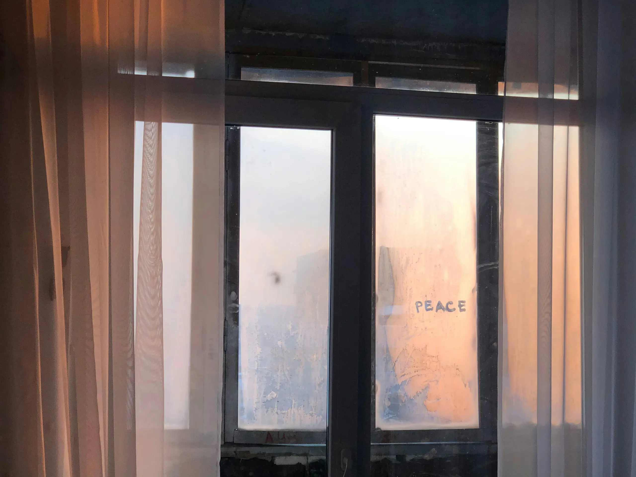 Beschlagenes Fenster, auf das PEACE geschrieben ist.