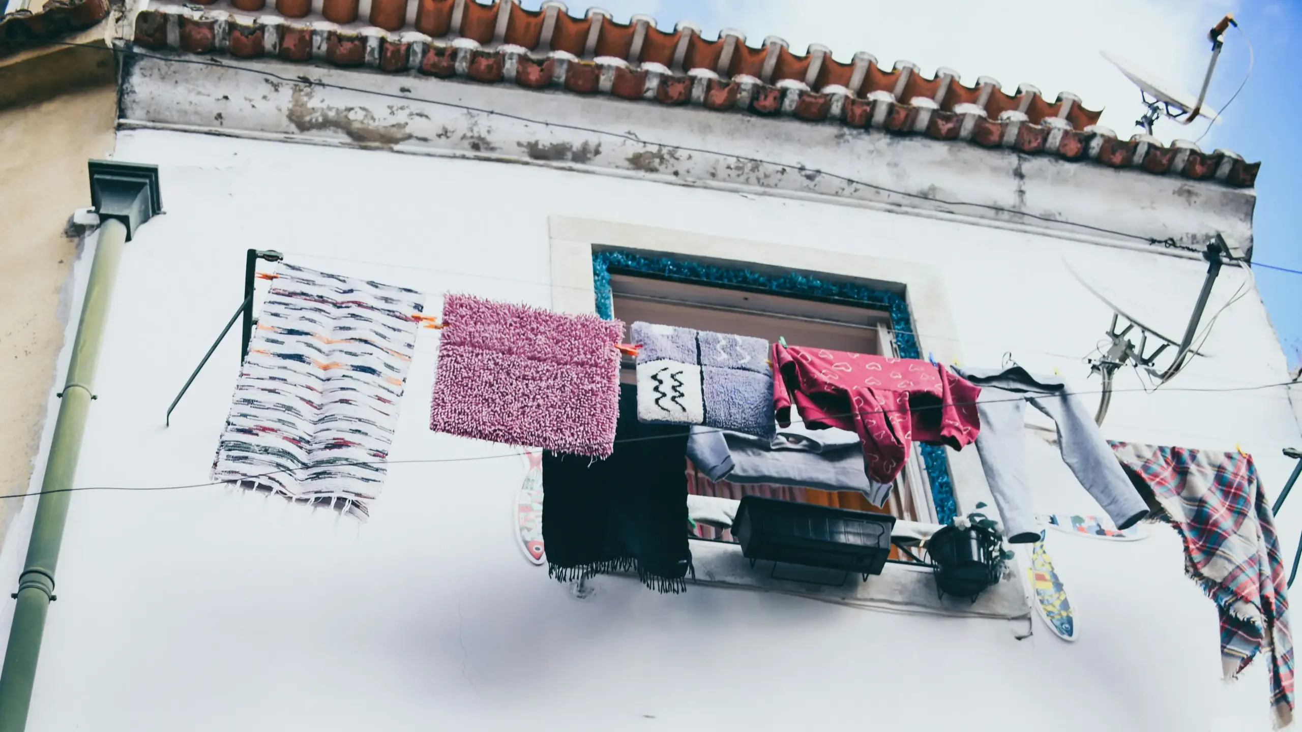 Wäsche, die an einem Weißen Haus getrocknet wird.